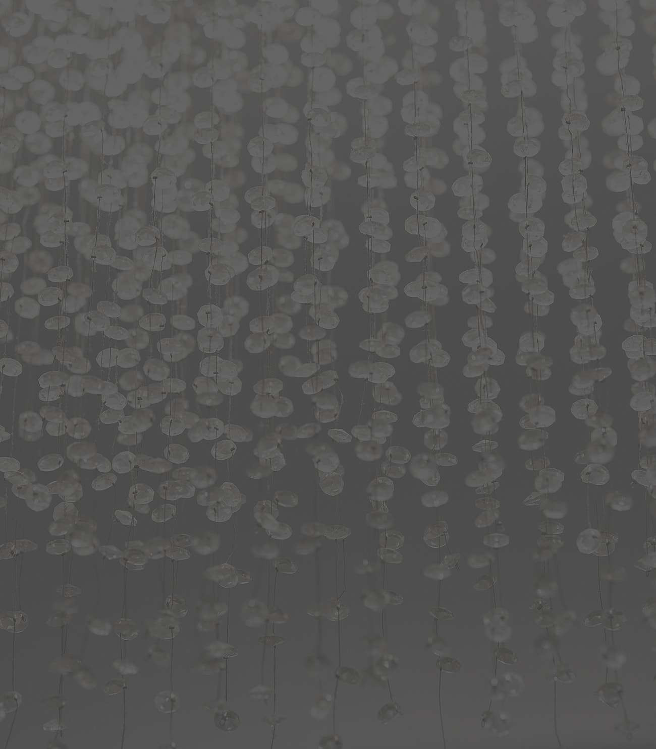 Abstract hanging beads on a dark background.