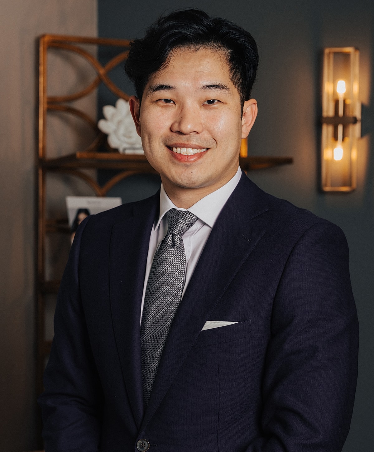 Smiling man in suit, professional setting.