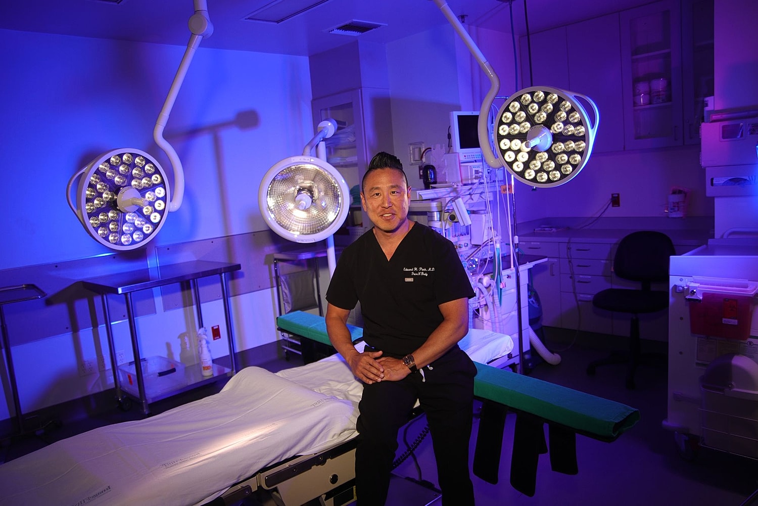 Surgeon in operating room with medical equipment.
