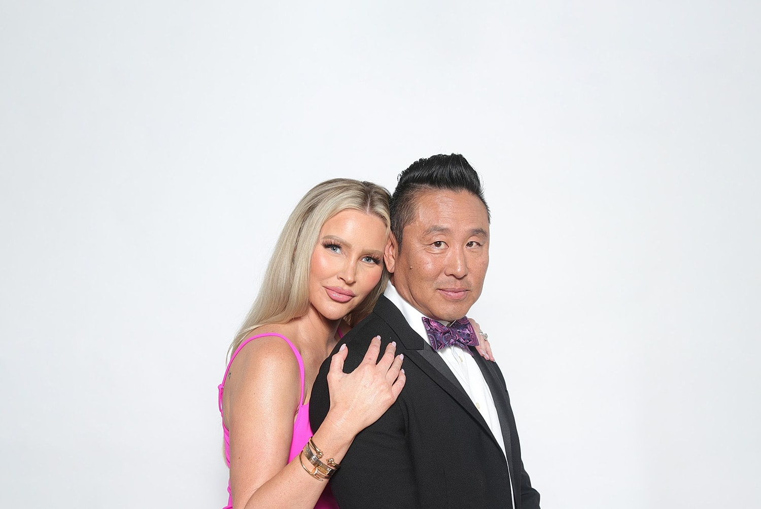 Couple posing together in formal attire.