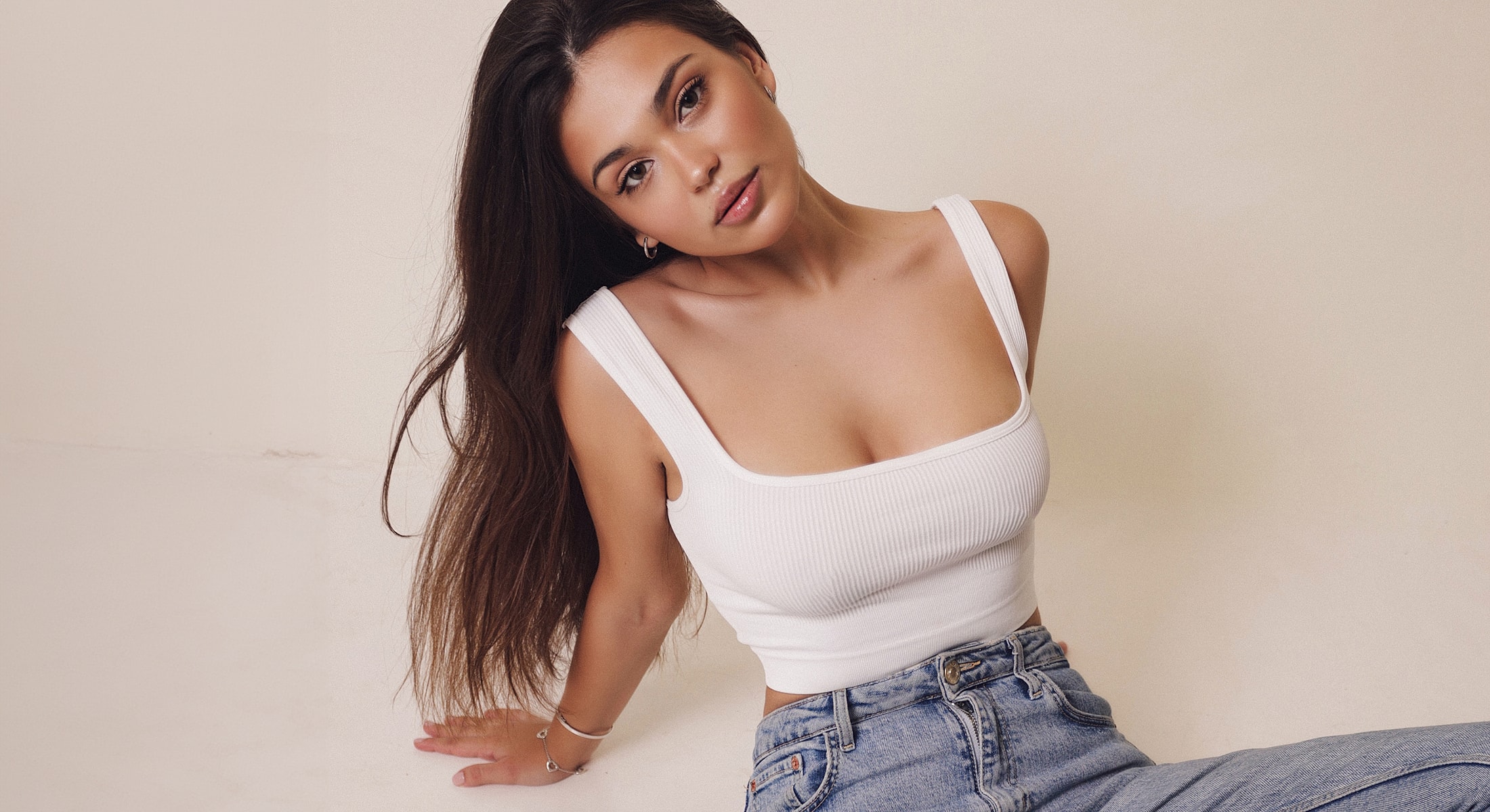 Young woman in white top and jeans.