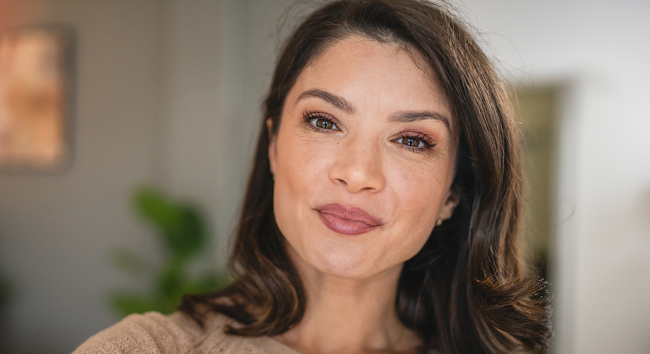 Woman smiling in a cozy indoor setting.